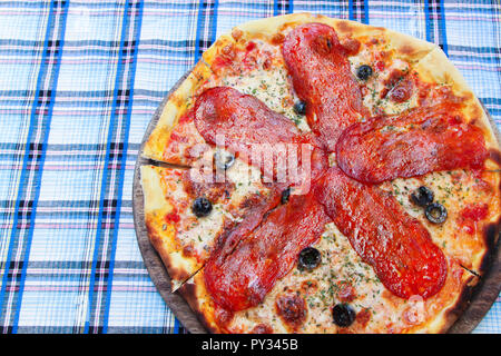 La pizza italiana con salame su una scheda woodeen Foto Stock