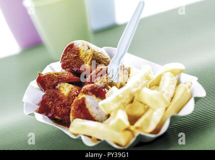 Currywurst mit pommes frites in Pappschaelchen Foto Stock