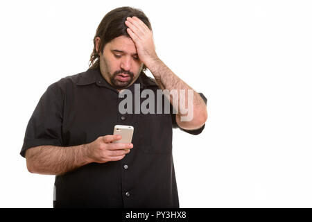 Fat uomo caucasico cercando stanco mentre si utilizza il telefono cellulare Foto Stock