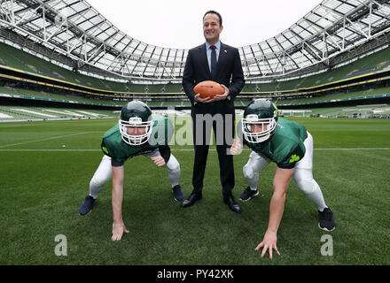 An Taoiseach Leo Varadkar con giocatori da Cork Admirals american football team Cillian McGillycuddy (sinistra) e Aidan acque, all'Aviva stadium di Dublino, per l'annuncio di piani per un periodo di cinque gioco American college football series. Foto Stock