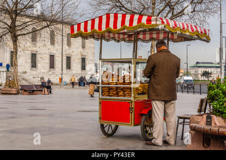 Istanbul, Turchia,aprile 5. 2012: l'uomo vendere simit (turco bagel) da un carrello. Foto Stock