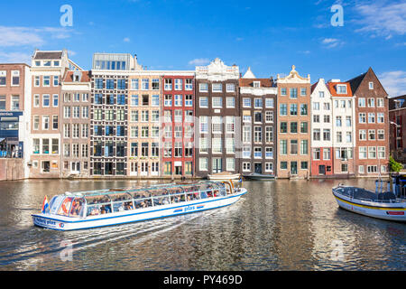 Case di Amsterdam su Damrak case con architettura olandese dal canale Canal Cruise boat lasciando Damrak Amsterdam Olanda Paesi Bassi EU Europe Foto Stock