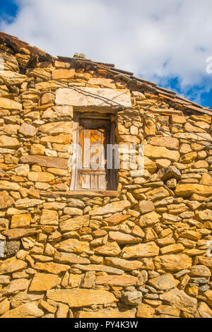 Dettaglio della pietra rustica facciata. Horcajuelo de la Sierra, provincia di Madrid, Spagna. Foto Stock