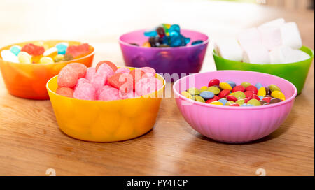 Pieno di caramelle in ciotole di plastica Foto Stock