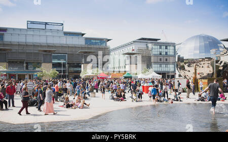 La gente a piedi attorno al cibo bancarelle in Millennium Square durante il cibo Connections festival, Bristol. Foto Stock