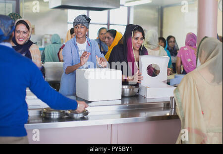 I membri di un tempio Sikh a Bristol servono il cibo la domenica mattina ai membri della comunità locale come parte del festival di Connessioni alimentari. Foto Stock