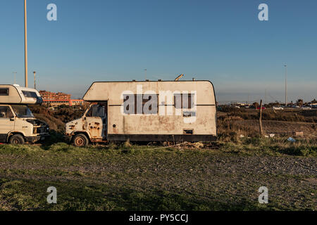 Vecchio gipsy sinistra rimorchio alla ruggine. Stile di vita fuorilegge, città italiana. Foto Stock