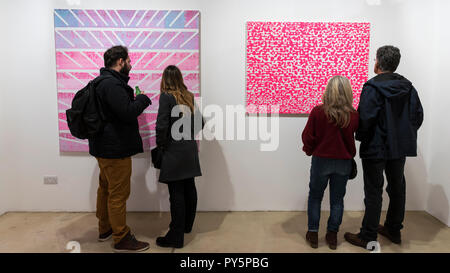 Londra, Regno Unito. Il 25 ottobre 2018. Visitatori vista (L a R) 'Pantheon', 2012 e 'Modello fucsia fluorescente', 2015, sia da Colin McCallum. Anteprima di 'metropolis', una mostra personale di questi ultimi dipinti da un artista Colin McCallum presso la Galleria della leva. Lo show è 26 Ottobre al 10 novembre 2018. Credito: Stephen Chung / Alamy Live News Foto Stock