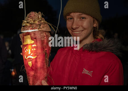 Hinton St George, Somerset, Regno Unito - 25 ottobre 2018. Una giovane donna detiene un 'Punkie' durante l'annuale "punkie notte' processione attorno a Hinton St George village. Un 'Punkie' è una scavata mangold o mangano-wrurzel con una candela accesa all'interno per rendere una lanterna. Sebbene le origini di custom sono oscure la leggenda narra che le mogli di Hinton St George è andato a hanno incontrato i loro mariti come sono tornato dalla Fiera Chiselbrough, tiene l'ultimo giovedì di ottobre. Hanno reso lanterne fuori scavata mangano-wurzels alla luce il loro modo. Credito: Tom Corban/Alamy Live News Foto Stock