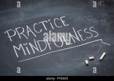 Pratica mindfulness - bianco gesso confuso la grafia su una lavagna Foto Stock