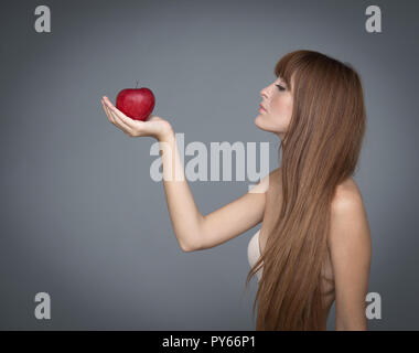 Varie espressione da ragazza giovane con apple frutta fresca su sfondo neutro Foto Stock