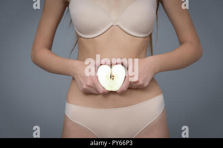 Varie espressione da ragazza giovane con apple frutta fresca su sfondo neutro Foto Stock