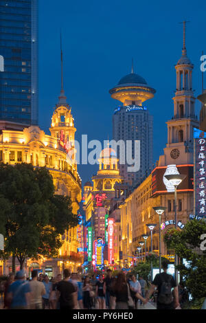 La folla di persone contro la città di Shanghai lungo una affollata trafficata Nanjing Road West, Shanghai, Cina, Asia di notte Foto Stock