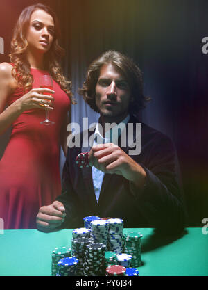 L uomo alla roulette tavolo circondato da belle donne Foto Stock