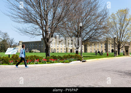 Lexington, Stati Uniti d'America - 18 Aprile 2018: Virginia Military Institute Donna che cammina bygreen prato durante la giornata soleggiata di fronte Clayton Hall Foto Stock