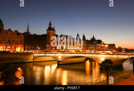 Panorama di Conciergerie e ponte illuminato Pont au cambia durante la notte, Parigi. Foto Stock