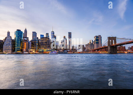 Vista Outdooors su NYC New York City Ponte di Brooklyn Park da East River, cityscape skyline al tramonto, crepuscolo, crepuscolo, blu ora, notte oscura, grattacielo Foto Stock