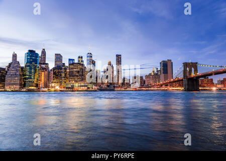 Vista Outdooors su NYC New York City Ponte di Brooklyn Park da East River, cityscape skyline al tramonto, crepuscolo, crepuscolo, blu ora, notte oscura, grattacielo Foto Stock