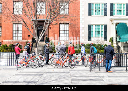 Washington DC, Stati Uniti d'America - 9 Marzo 2018: un gruppo di turisti in bicicletta, biciclette in piedi in attesa di Pennsylvania Avenue, city tour guidato guida su marciapiede Foto Stock