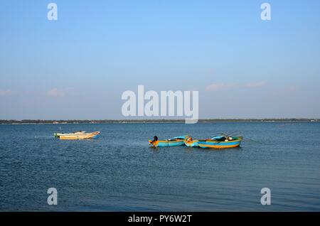 Più blu e giallo barche ormeggiate ancorata nelle acque di Jaffna nello Sri Lanka Foto Stock