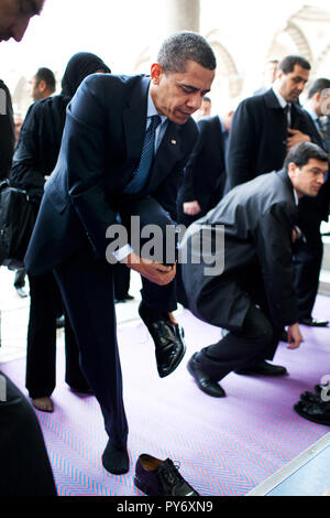 Il presidente Barack Obama rimuove le sue scarpe come egli si prepara a visitare la Moschea Blu il 7 aprile 2009, a Istanbul. Gazzetta White House Photo by Pete Souza Foto Stock