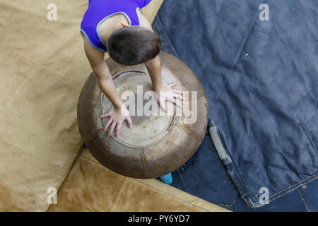 Giovane sportivo di ginnastica formazione sul cavallo a fungo top view image Foto Stock