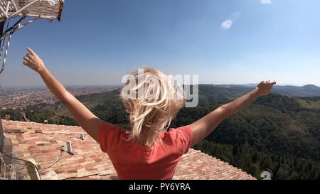 La donna si gode il panorama superiore di Bologna La città dal punto di vista della torre della Madonna di San Luca santuario sulle colline di Bologna. Foto Stock