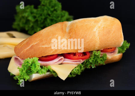 Con sandwich con prosciutto e formaggio, pomodori, lattuga su pietra. Foto Stock