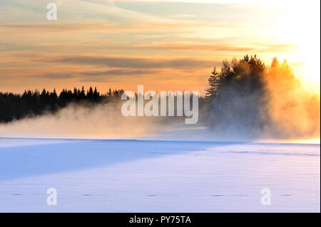 Mist over freezing river on a cold winter. Sunset view. Foto Stock
