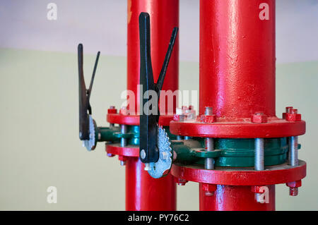 Le valvole a saracinesca installata su tubi verniciati in rosso. Background Industriale. Foto Stock