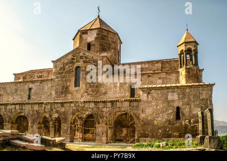 Odzun monastero con una galleria ad arco e la torre campanaria, basalto attraversa il lato sud al tramonto Foto Stock