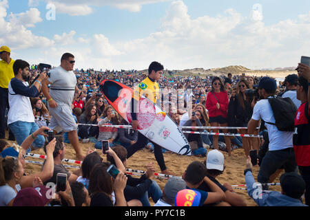 PENICHE, Portogallo - 20 ottobre 2018: Gabriel Medina in esecuzione all'oceano tra la folla di surf ventilatori durante il Mondiale di Surf del campionato 2018 MEO Rip Cur Foto Stock