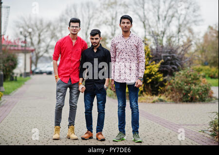 Tre ragazzi indiani gli studenti amici camminando sulla strada. Foto Stock
