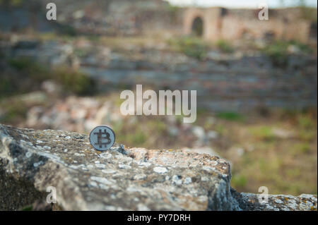 Moneta di bit sulla vecchia pietra e muro di mattoni Foto Stock