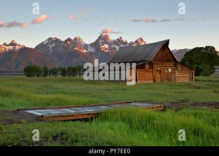 WY02519-00...WYOMING - Alba sul Grand Teton e uno storico antico fienile da mormone riga nel Parco Nazionale di Grand Teton. Foto Stock