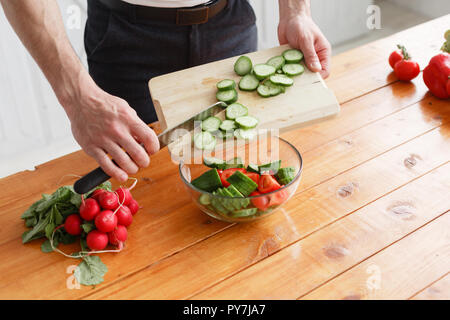 Lo chef taglia verdure. Il concetto di prodotti eco-compatibili per la cottura Foto Stock