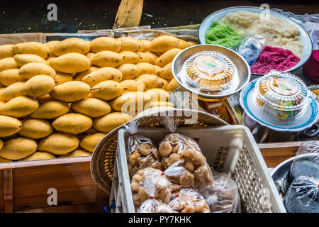 Mango e riso appiccicoso essendo servita da una barca al mercato galleggiante di Damnoen Saduak Foto Stock