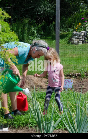 Ragazza giovane e maestro di irrigazione in giardino giardino camp, Maine, Stati Uniti d'America Foto Stock