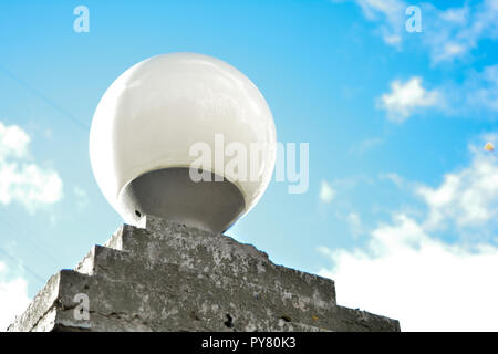 Spegnere la luce bianca della lampada di strada in città, cloud e cielo blu nel pomeriggio, la conservazione dell'energia. L'esterno rotondo in vetro lampada sul basamento in pietra Foto Stock