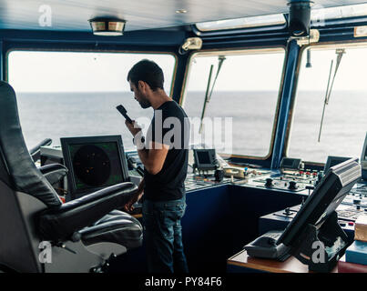 Marine Navigational officer è segnalato da una radio VHF Foto Stock