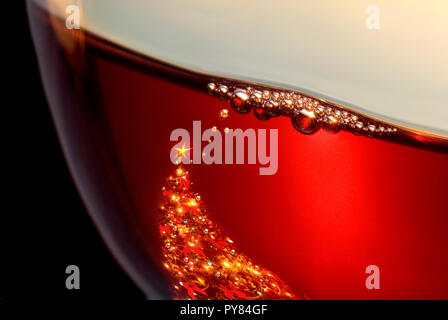 LUCI DELL'ALBERO DEL VINO ROSSO DI NATALE LUCI DELLA CENA DELL'ALBERO LUCI del bicchiere di vino luci dell'albero di Natale riflettono le baubles che si innalzano in bollicine durante le feste di degustazione di vini Foto Stock