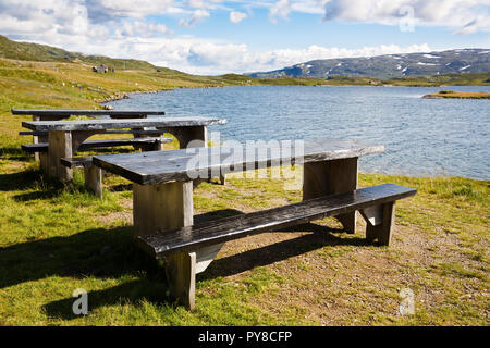 Paesaggio con montagne, lago, panche di legno, Cielo e nubi in Norvegia. Foto Stock