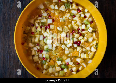 Le sane organico insalata di frutta in giallo coppa in plastica. Alimenti biologici. Foto Stock