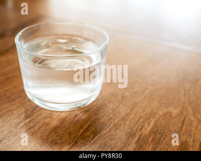 Acqua fredda potabile in vetro su un tavolo di legno sfondo con copia spazio. Foto Stock