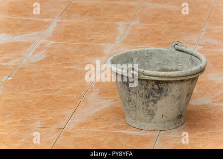 Calcestruzzo colorato secchio di plastica sul pavimento piastrellato Foto Stock
