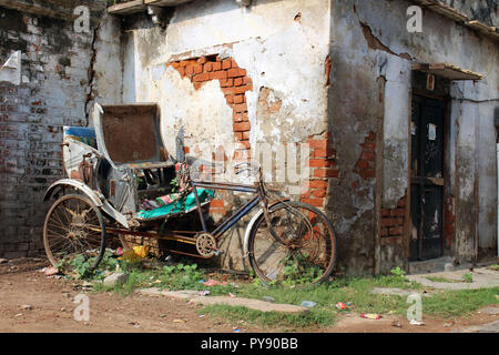 Il vecchio e abbandonato risciò bicicletta e di fronte a un cancello in Varanasi. Preso in India, Agosto 2018. Foto Stock