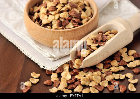 Assorti cereali per la prima colazione nella ciotola di legno su sfondo di legno Foto Stock