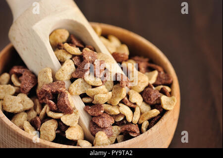 Assorti cereali per la prima colazione nella ciotola di legno su sfondo di legno Foto Stock