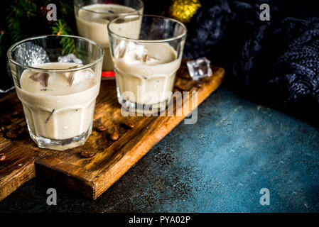 Irish cream cocktail o un liquore tradizionale winter drink di natale, scuro dello sfondo arrugginito con abete rami, i chicchi di caffè e composizioni di natale Foto Stock