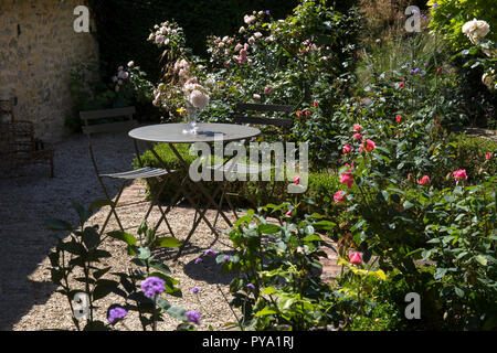 Tavolo in metallo e sedie nel giardino di rose con box coperture in english country garden,l'Inghilterra,l'Europa Foto Stock